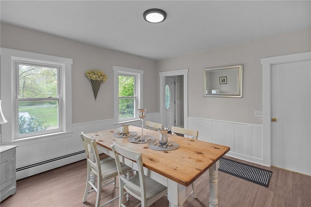 183 Annaquatucket Rd, North Kingstown, RI 02852 - dining room with baseboard heating, wainscoting, and light wood finished floors