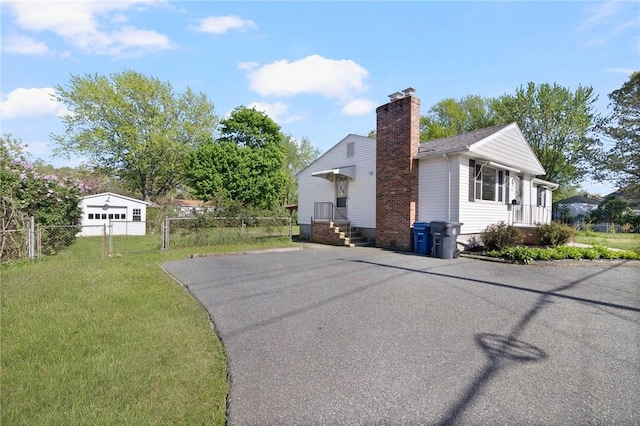 view of side of property with a chimney and driveway
