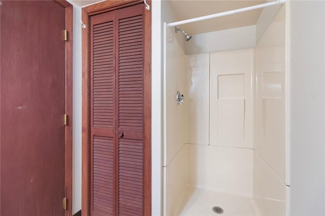 bathroom with a stall shower and a closet