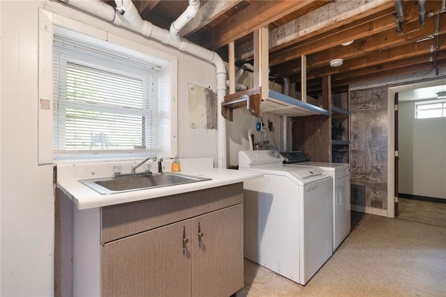 laundry room with a sink, washing machine and dryer, and light flooring