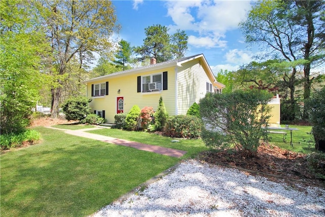 bi-level home with a chimney and a front lawn