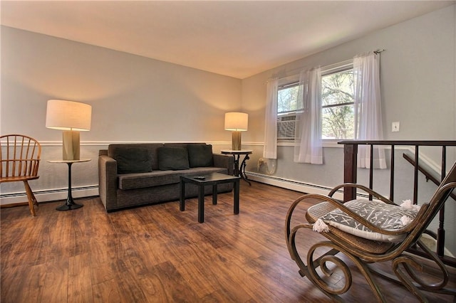 living area with a baseboard heating unit and dark wood finished floors