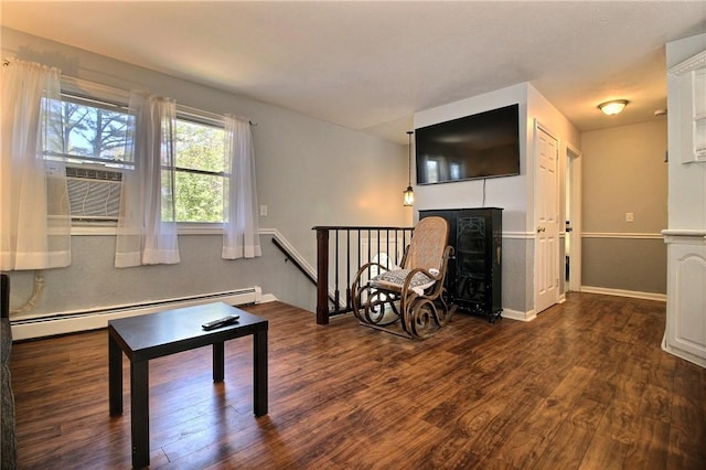 living area with a baseboard heating unit, dark wood-type flooring, cooling unit, and a fireplace