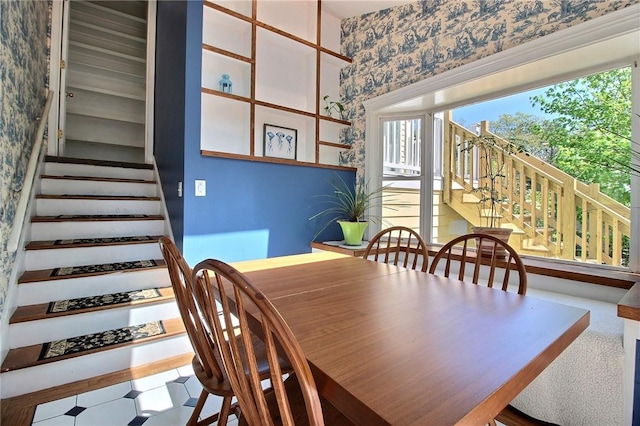 dining room featuring wallpapered walls and stairway