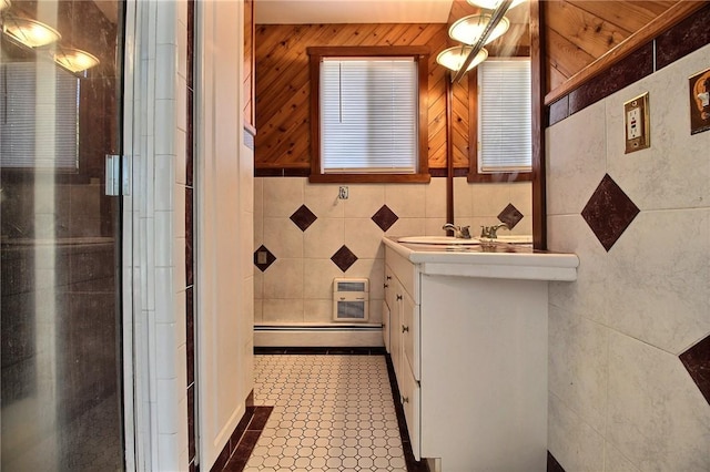 bathroom with baseboard heating, vanity, tile walls, and a shower stall