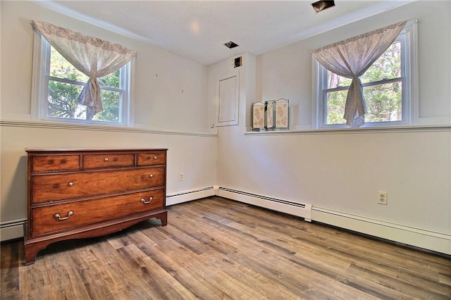 bedroom featuring wood finished floors, a baseboard radiator, and baseboard heating
