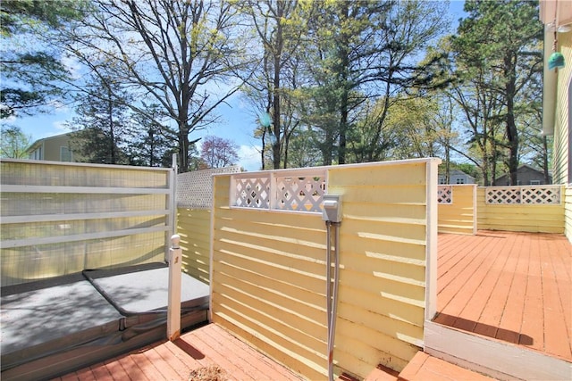 wooden terrace featuring fence and a gate