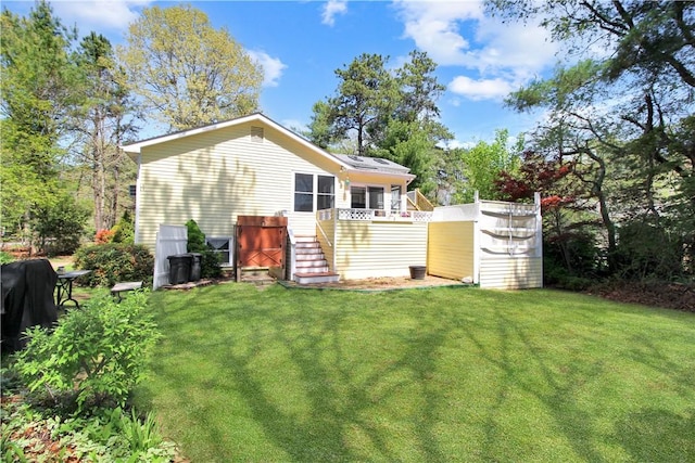rear view of house featuring stairway, a yard, and a wooden deck