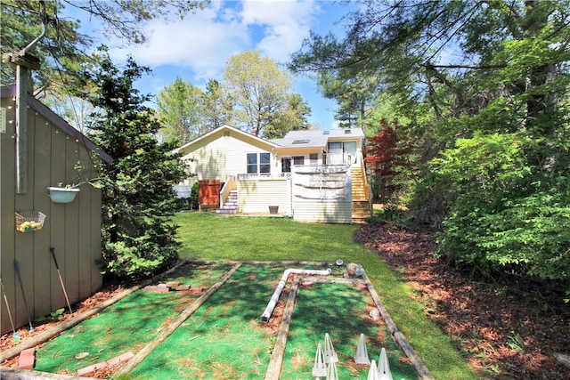 view of green lawn featuring stairs and a wooden deck