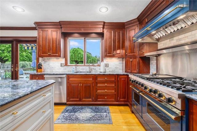 831 N Quidnessett Rd, North Kingstown, RI 02852 - kitchen featuring appliances with stainless steel finishes, custom range hood, a sink, stone counters, and backsplash