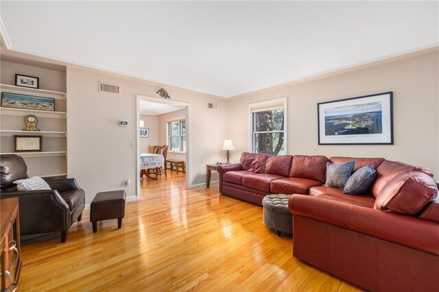 831 N Quidnessett Rd, North Kingstown, RI 02852 - living area with light wood-style floors, plenty of natural light, built in shelves, and baseboards