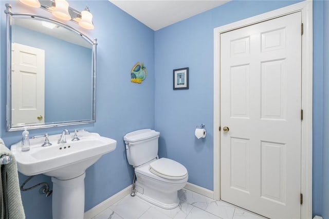 831 N Quidnessett Rd, North Kingstown, RI 02852 - bathroom featuring baseboards, marble look tiles, and toilet