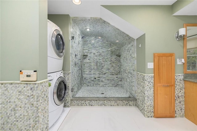 831 N Quidnessett Rd, North Kingstown, RI 02852 - washroom featuring stacked washer and clothes dryer, tile walls, a wainscoted wall, and tile patterned floors
