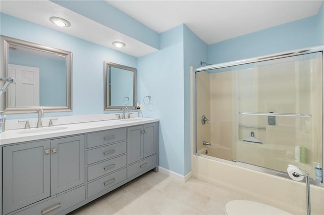 831 N Quidnessett Rd, North Kingstown, RI 02852 - full bathroom featuring enclosed tub / shower combo, double vanity, baseboards, tile patterned flooring, and toilet