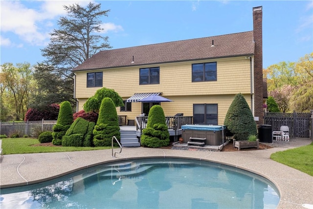 831 N Quidnessett Rd, North Kingstown, RI 02852 - back of property featuring a hot tub, a deck, a chimney, fence, and central AC