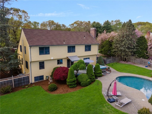 831 N Quidnessett Rd, North Kingstown, RI 02852 - back of property with a chimney, a patio area, and a shingled roof