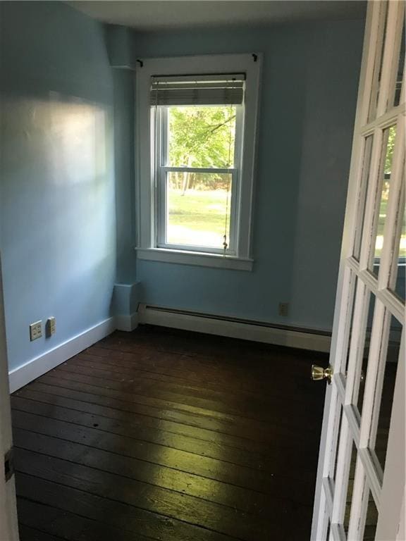 16 Gough Ave, West Warwick, RI 02893 - spare room featuring baseboard heating, dark wood-type flooring, and baseboards