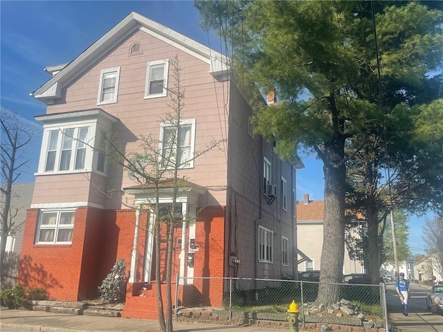 view of front of property featuring fence and brick siding