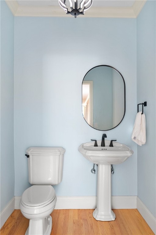 38 Miss Fry Dr, East Greenwich, RI 02818 - half bath with wood finished floors, toilet, a chandelier, baseboards, and crown molding