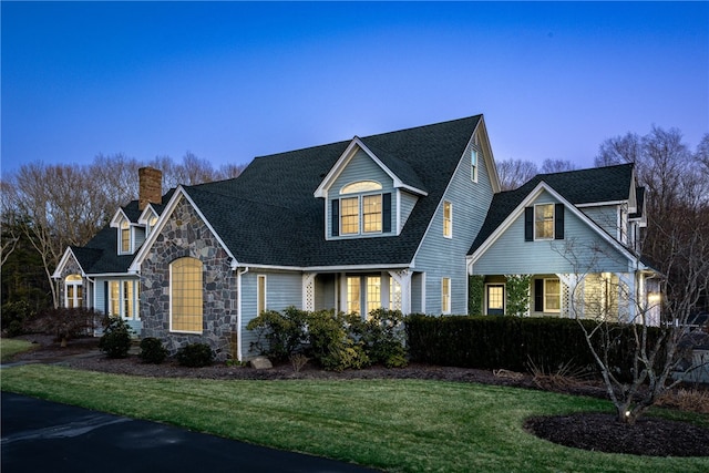 38 Miss Fry Dr, East Greenwich, RI 02818 - view of front of house featuring a chimney, stone siding, a front lawn, and roof with shingles