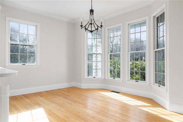 38 Miss Fry Dr, East Greenwich, RI 02818 - unfurnished dining area with healthy amount of natural light, a chandelier, wood finished floors, and ornamental molding