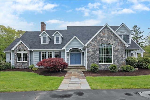 38 Miss Fry Dr, East Greenwich, RI 02818 - view of front of house featuring stone siding, a chimney, a front yard, and roof with shingles