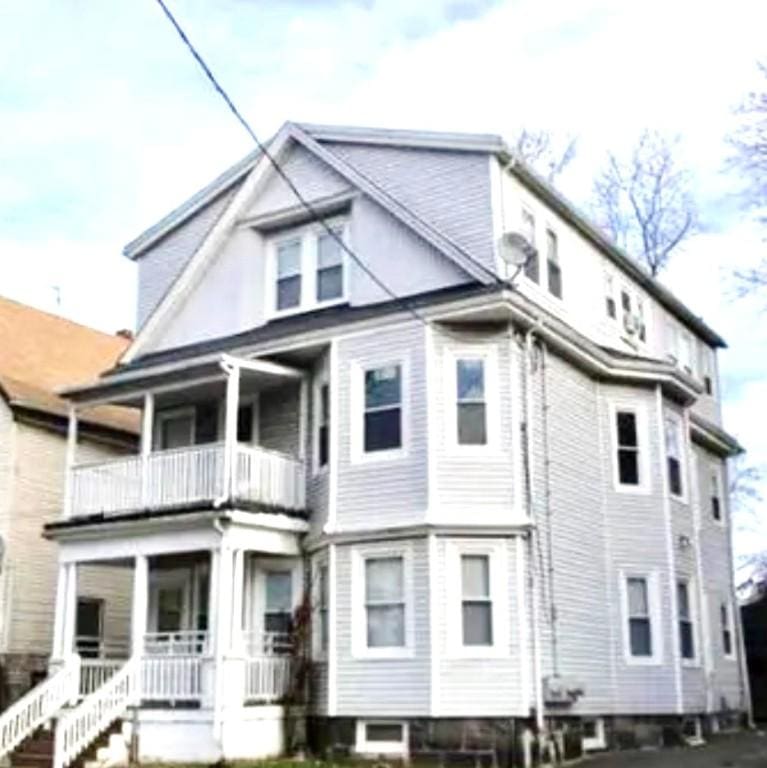 back of house with a balcony and covered porch