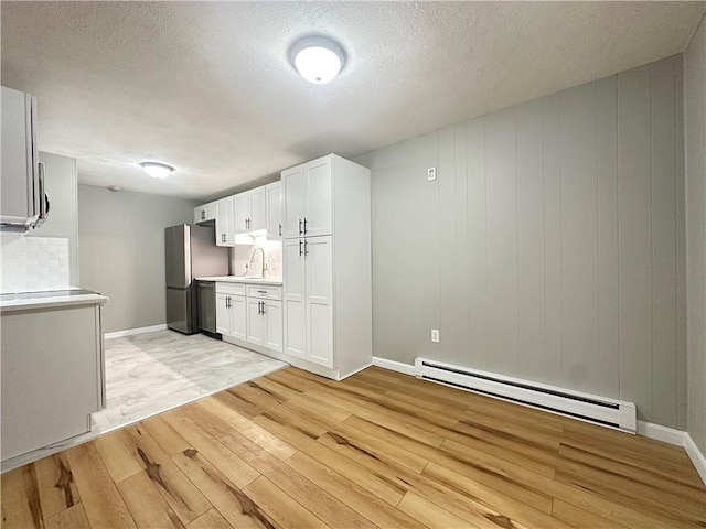 300 Smithfield Rd Unit B3-18, North Providence, RI 02904 - kitchen featuring a baseboard heating unit, light wood-style flooring, light countertops, stainless steel appliances, and a textured ceiling