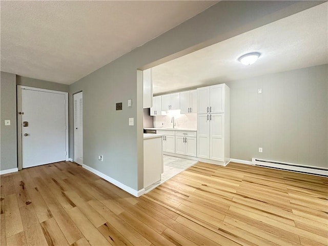 300 Smithfield Rd Unit B3-18, North Providence, RI 02904 - unfurnished living room with light wood finished floors, baseboard heating, baseboards, and a sink