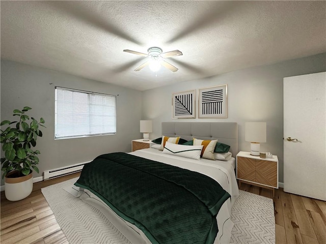300 Smithfield Rd Unit B3-18, North Providence, RI 02904 - bedroom with baseboard heating, wood finished floors, a ceiling fan, a textured ceiling, and baseboards