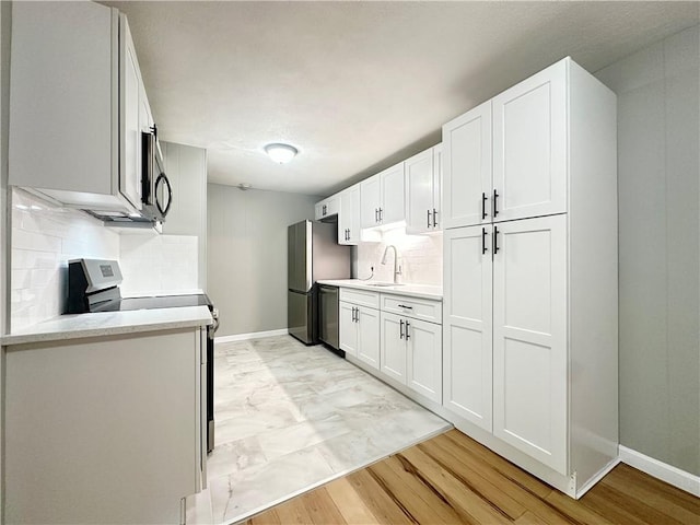 300 Smithfield Rd Unit B3-18, North Providence, RI 02904 - kitchen featuring stainless steel appliances, tasteful backsplash, a sink, light countertops, and baseboards