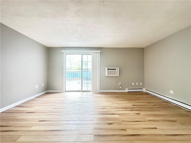 300 Smithfield Rd Unit B3-18, North Providence, RI 02904 - spare room featuring an AC wall unit, light wood-style flooring, a textured ceiling, baseboards, and a baseboard heating unit