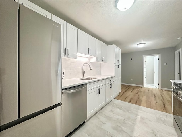 300 Smithfield Rd Unit B3-18, North Providence, RI 02904 - kitchen with appliances with stainless steel finishes, a sink, light countertops, baseboards, and white cabinets