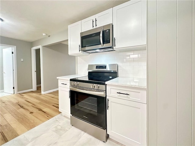 300 Smithfield Rd Unit B3-18, North Providence, RI 02904 - kitchen with appliances with stainless steel finishes, white cabinetry, tasteful backsplash, baseboards, and light stone counters