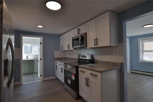 115 Sherman Farm Rd, Burrillville, RI 02830 - kitchen featuring appliances with stainless steel finishes, white cabinetry, wood finished floors, and baseboards