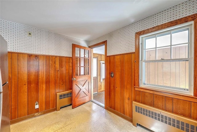 14 Manchester St, Bristol, RI 02809 - entrance foyer featuring radiator heating unit, wallpapered walls, plenty of natural light, wainscoting, and wooden walls