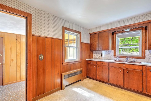 14 Manchester St, Bristol, RI 02809 - kitchen featuring radiator, a sink, brown cabinetry, light countertops, and wallpapered walls