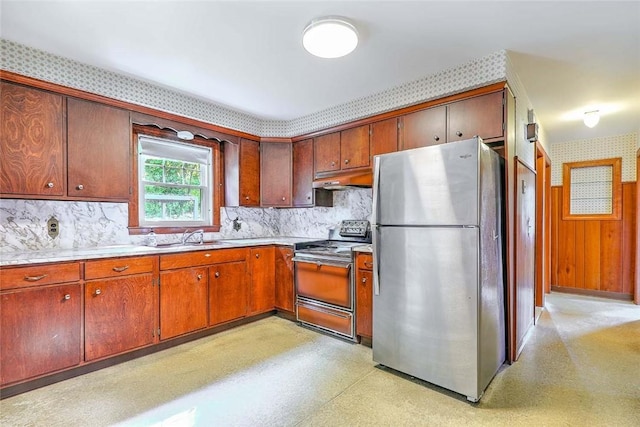 14 Manchester St, Bristol, RI 02809 - kitchen with freestanding refrigerator, range with electric stovetop, under cabinet range hood, backsplash, and wallpapered walls