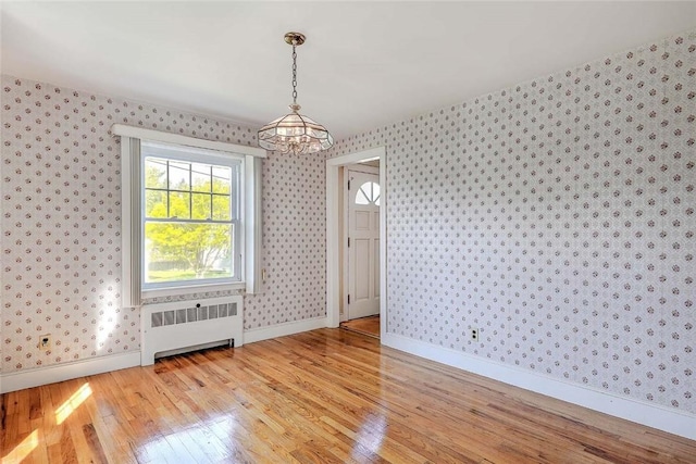 14 Manchester St, Bristol, RI 02809 - unfurnished dining area featuring radiator heating unit, a chandelier, wallpapered walls, light wood-style floors, and baseboards