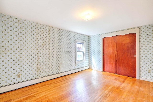 14 Manchester St, Bristol, RI 02809 - unfurnished bedroom with a baseboard heating unit, wallpapered walls, and wood finished floors