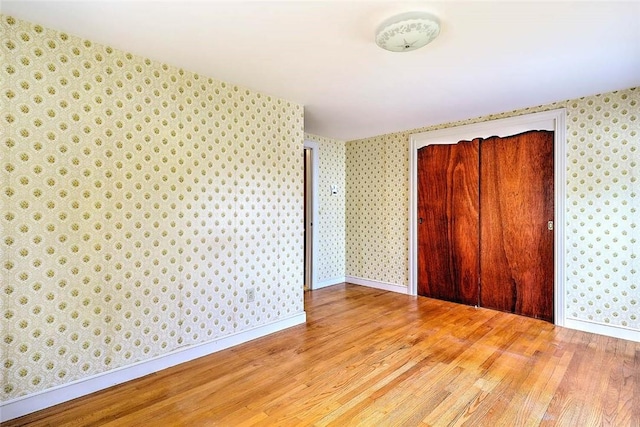 14 Manchester St, Bristol, RI 02809 - spare room with wallpapered walls, wood finished floors, and baseboards