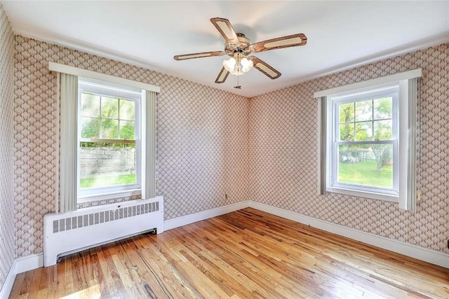 14 Manchester St, Bristol, RI 02809 - unfurnished room featuring radiator, wood finished floors, and healthy amount of natural light