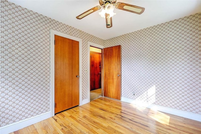 14 Manchester St, Bristol, RI 02809 - unfurnished bedroom featuring wood finished floors, wallpapered walls, baseboards, and a ceiling fan