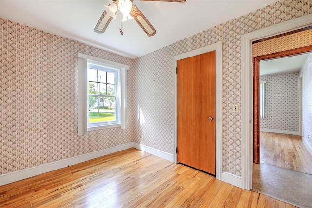 14 Manchester St, Bristol, RI 02809 - unfurnished bedroom featuring wood finished floors, wallpapered walls, baseboards, and ceiling fan