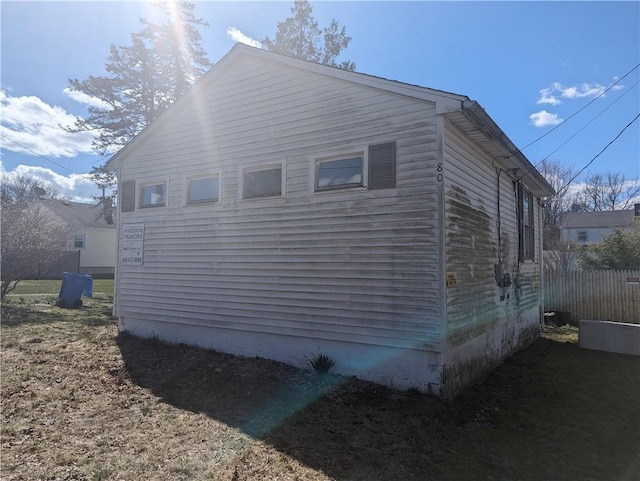 view of side of home featuring fence