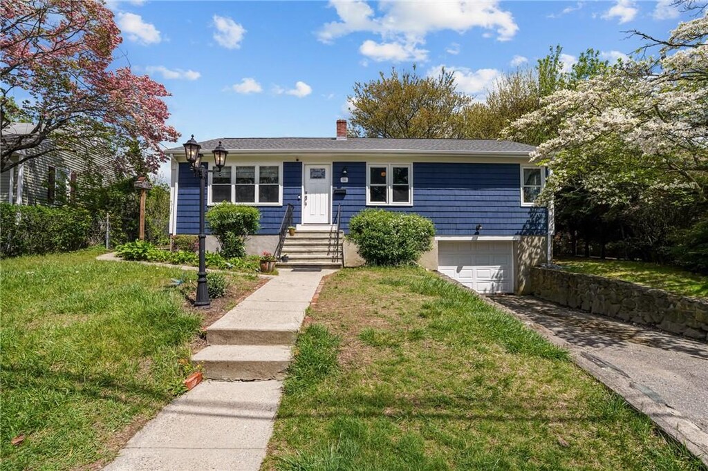 14 Simpson St, North Providence, RI 02911 - view of front of home with a garage, driveway, a front yard, and a chimney