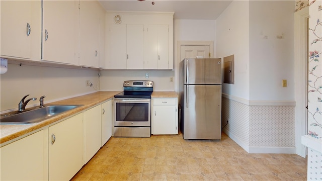45 Ayrault Ave Unit 8, Newport, RI 02840 - kitchen featuring appliances with stainless steel finishes, a sink, light countertops, wallpapered walls, and white cabinets