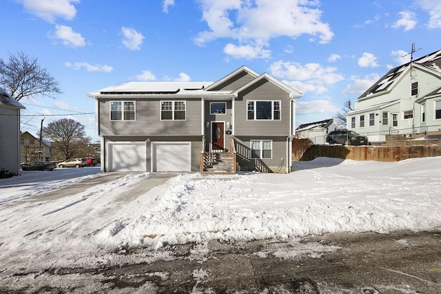 40 Burnside Ave, Woonsocket, RI 02895 - bi-level home with solar panels, an attached garage, fence, and concrete driveway
