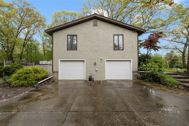 218 Burnt Cedar Dr, North Kingstown, RI 02852 - view of property exterior with concrete driveway, a garage, and fence