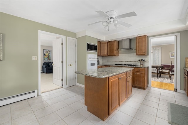 218 Burnt Cedar Dr, North Kingstown, RI 02852 - kitchen featuring wall chimney exhaust hood, oven, stainless steel microwave, gas cooktop, and baseboard heating